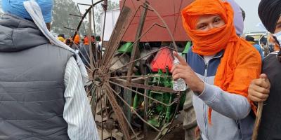 Farmers at Shambhu cover their faces to protect themselves from tear gases. Some are pictured with heavy equipment. Photo: Vivek Gupta/The Wire