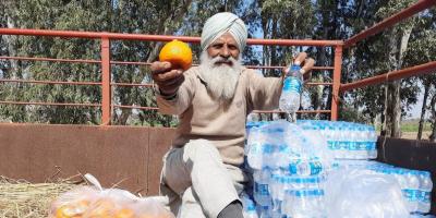 A farmer offering everyone water and oranges at Shambhu border. Photo: Rohit Kumar